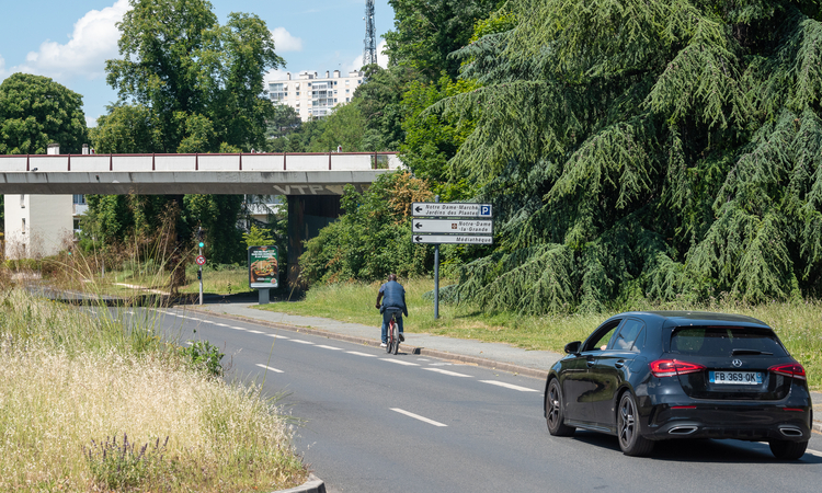 Vue d'une voie de circulation avec une voiture et un deux-roues